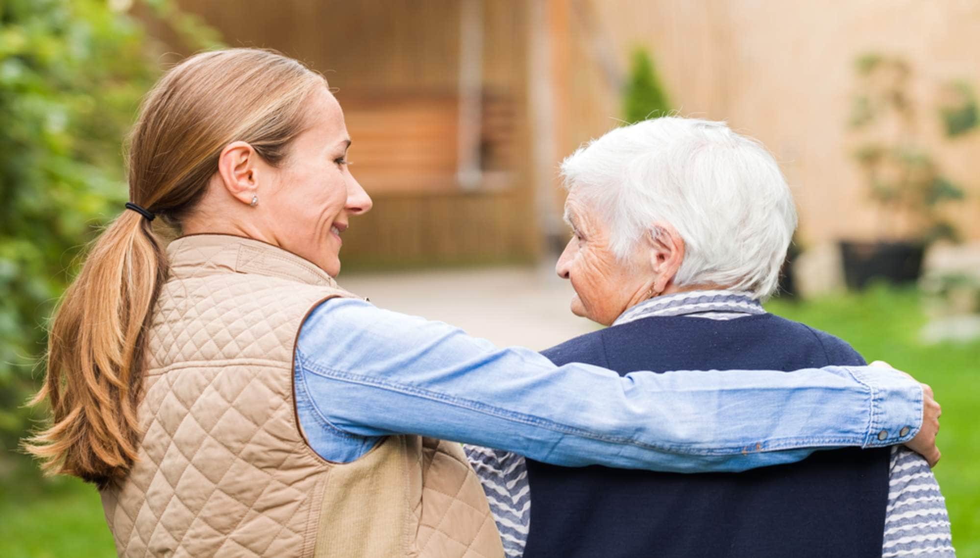 Carer walking with elderly woman