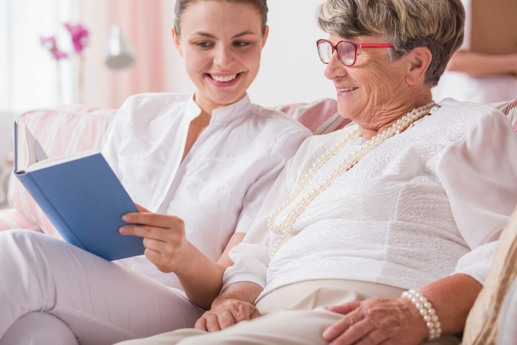 Carer helping elderly woman with learning disabilities