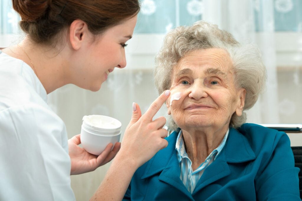 Carer helping elderly woman with personal care