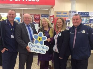 Tommy Dunne, Dementia campaigner posing with Dementia Friends sign 