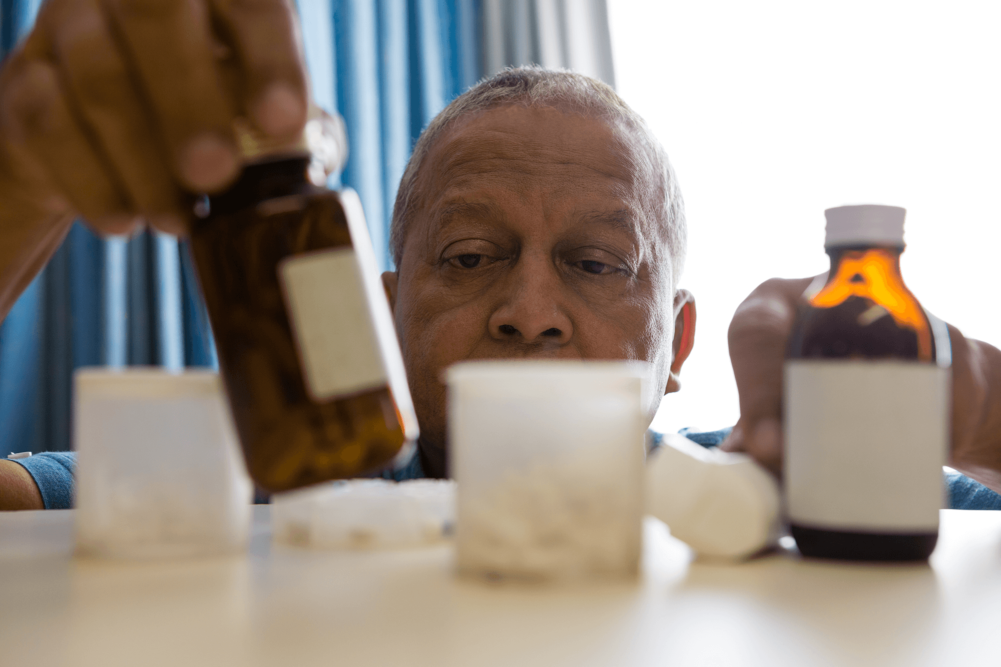 older man taking medication at home to stay well in winter