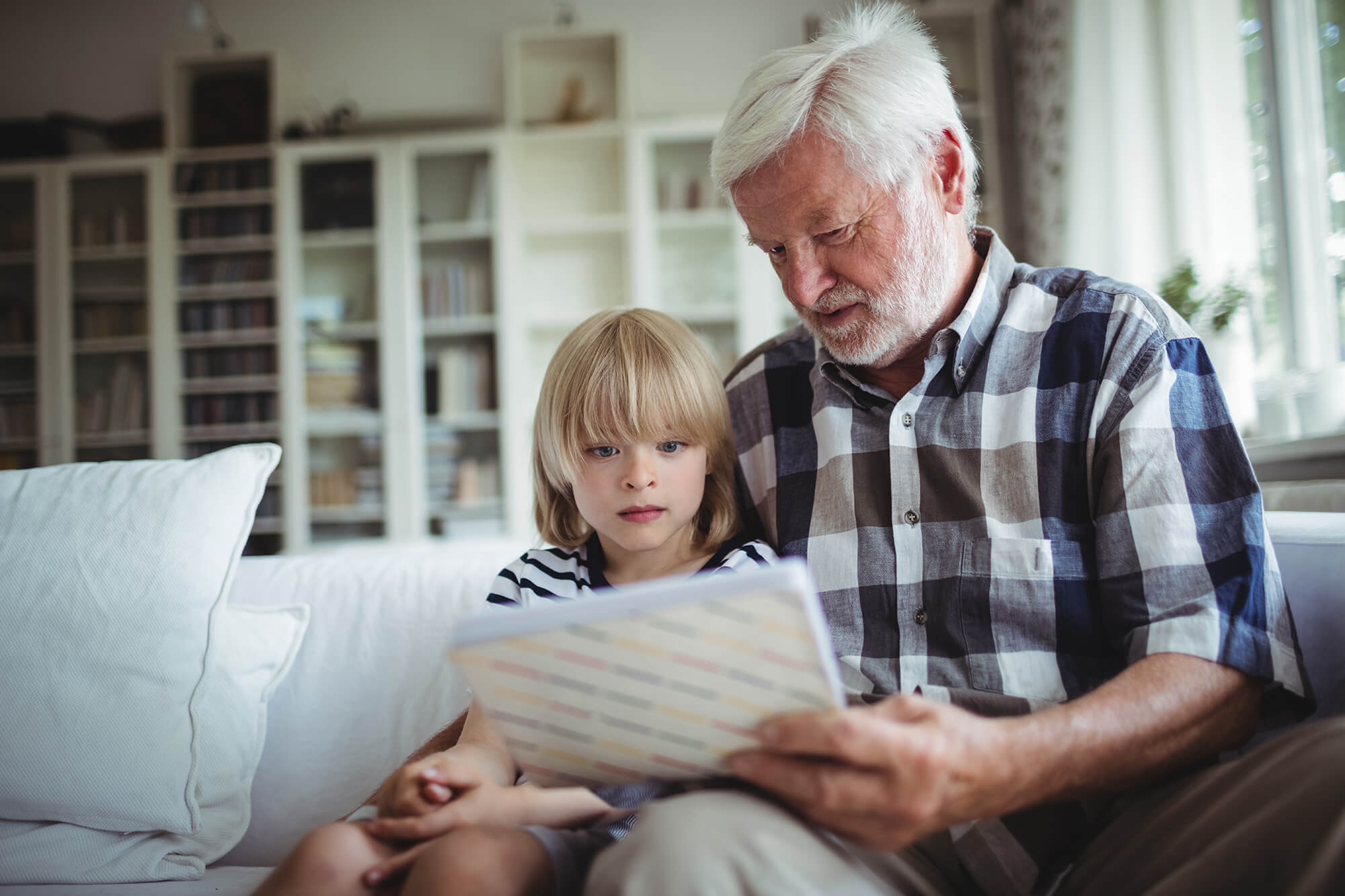 Granddad looks at photo album on valentine's to reminisce with family