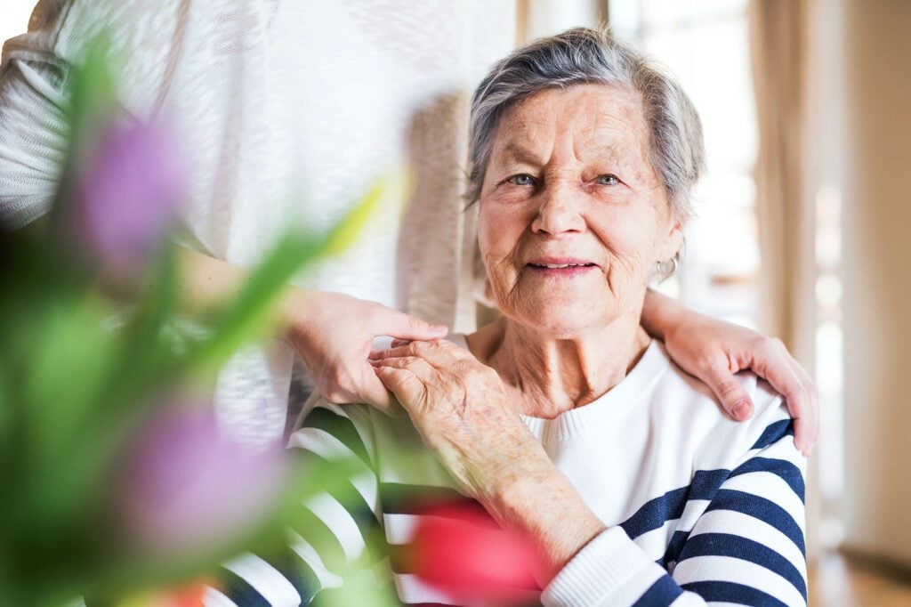 Elderly woman supported by her family