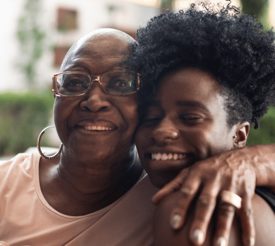 A mother and daughter hug affectionately while smiling