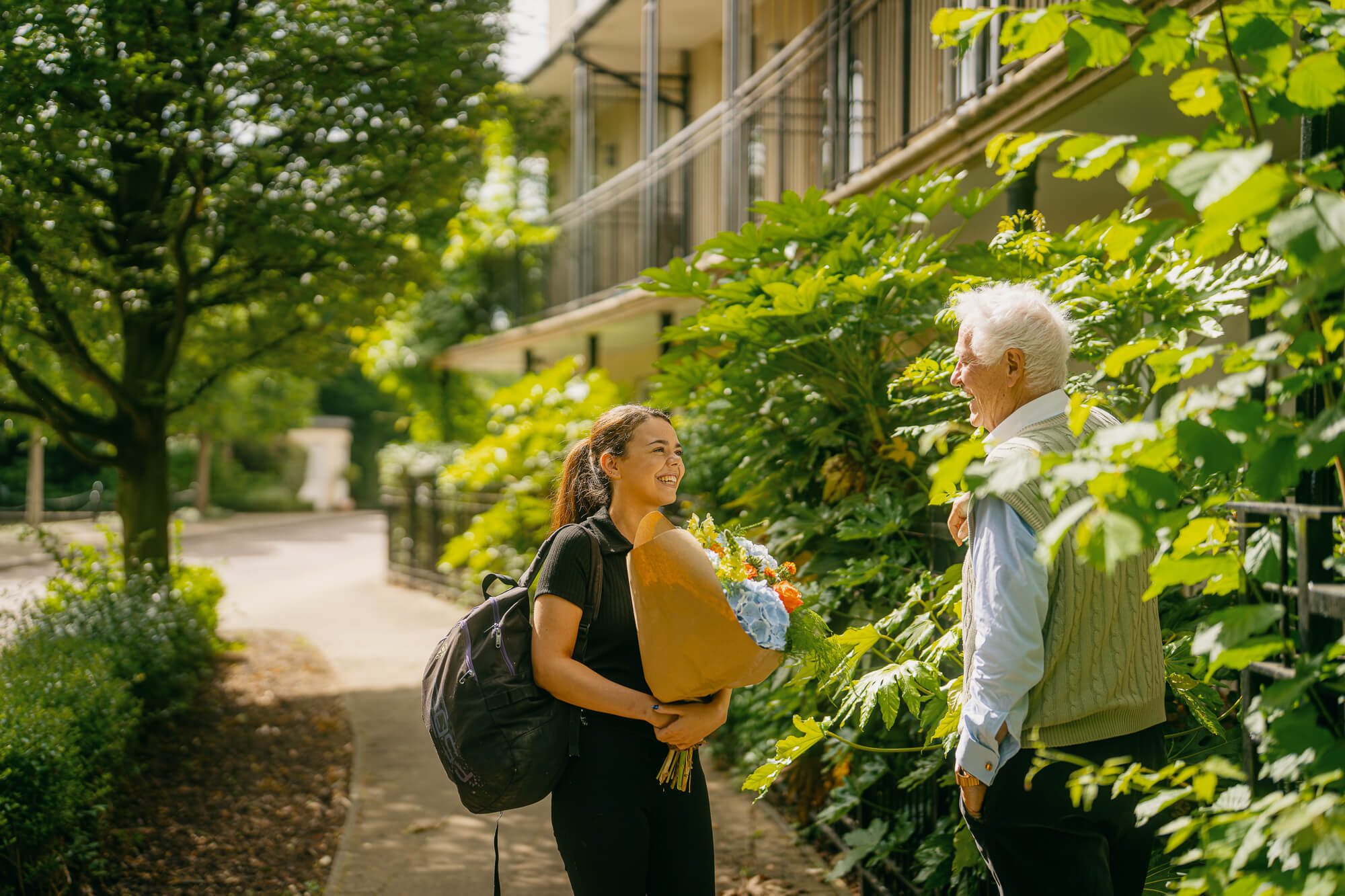 A young live-in carer arrives with a bunch of flowers on her first day with her new client.